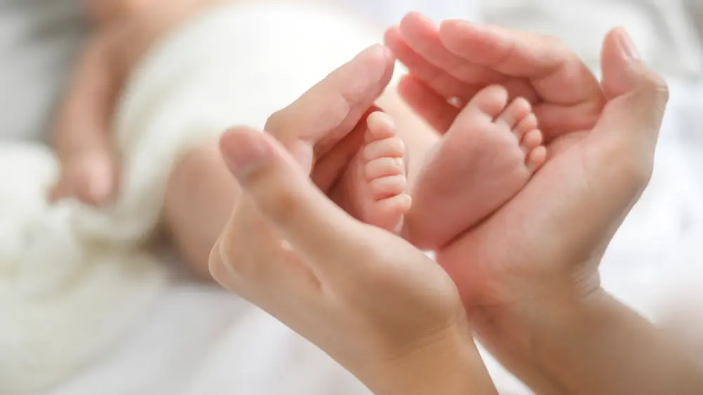 Close Hand Holding New Born Baby S Feet Cropped